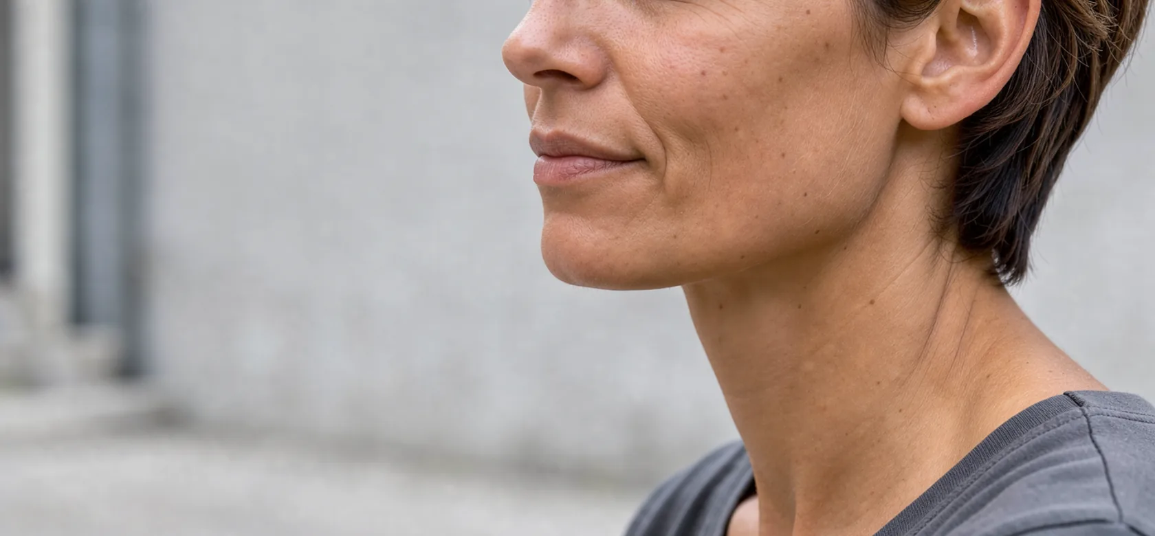 A woman's cheek and chin in three-quarter profile, with natural texture visible.